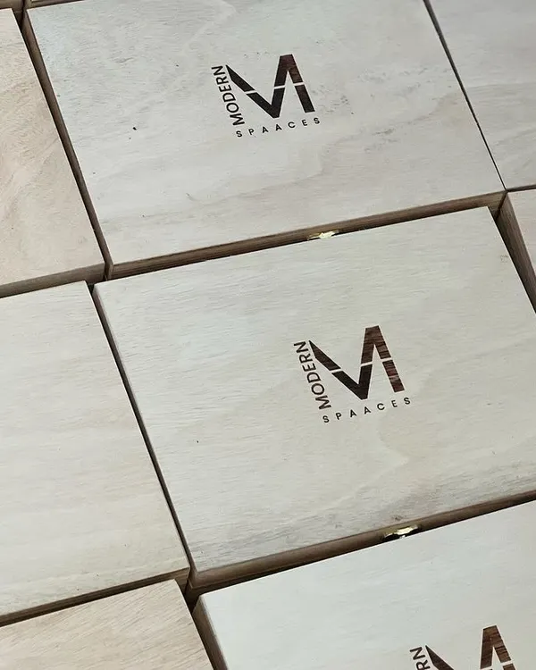 A clean and professional look for corporate gifting. These wooden boxes feature the 'Modern Spaaces' logo engraved directly onto the lid, creating a lasting brand impression.