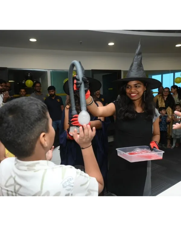 Our witch-hatted scientist demonstrates the 'Genie in a Bottle' experiment, creating a dramatic plume of smoke that captivates the young audience.
