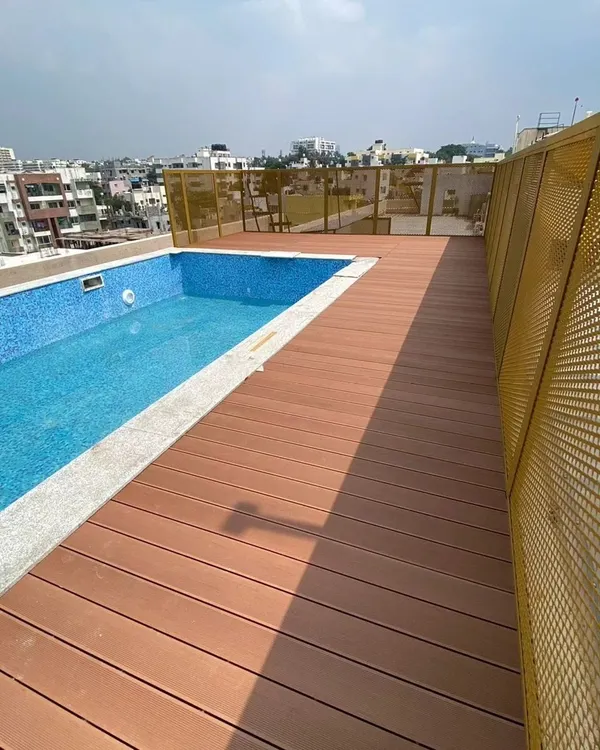 This rooftop pool area was upgraded with our water-resistant WPC decking. The warm wood-look finish provides a safe, non-slip surface that beautifully complements the cool blue of the pool tiles.