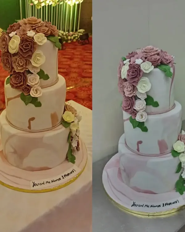 A beautiful three-tiered wedding cake with a cascade of handcrafted sugar roses in dusty pink and white. The marbled effect on the fondant adds a touch of modern elegance, perfect for a sophisticated reception.