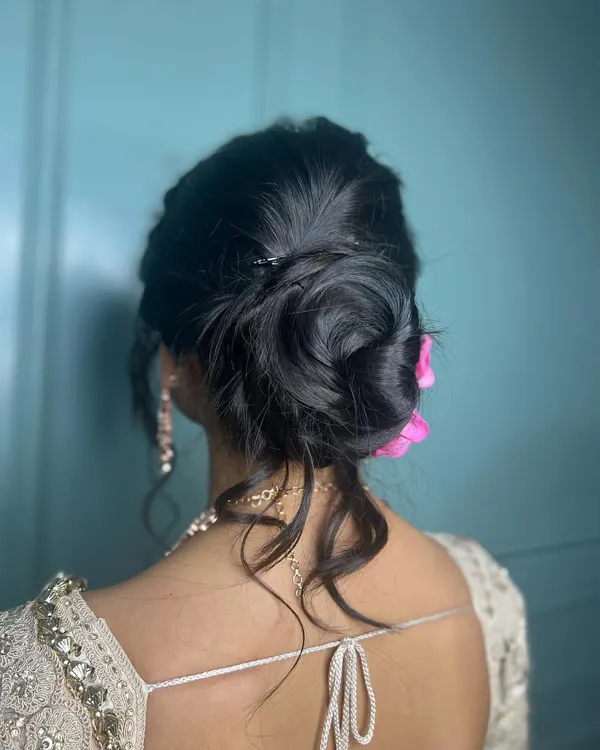 A beautiful and intricate messy bun, perfect for a reception or engagement. The soft tendrils frame the face beautifully.