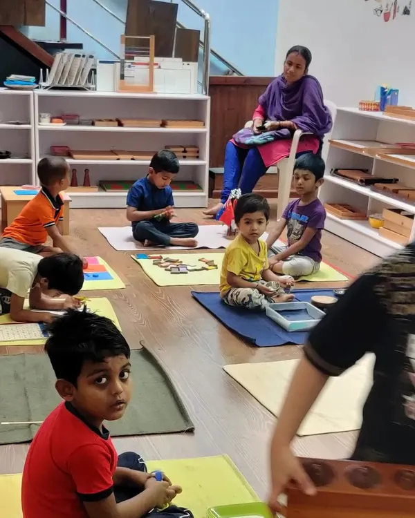 We have an open-door policy for parents. Here, a parent observes the classroom, a practice common in pure Montessori environments. This allows parents to see their children's progress and understand our child-led learning philosophy.