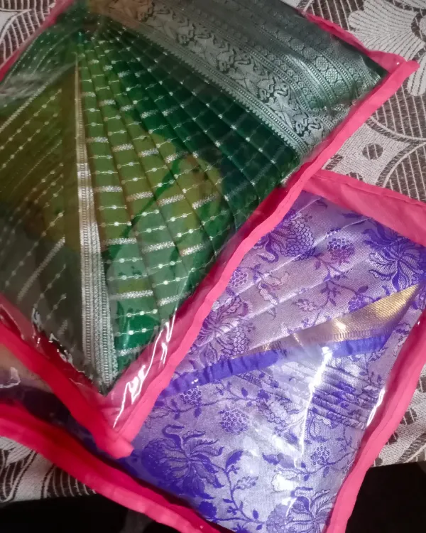 Two sarees, pleated and packed in individual saree bags with a clear window. This keeps them organized and protected until you're ready to wear them.