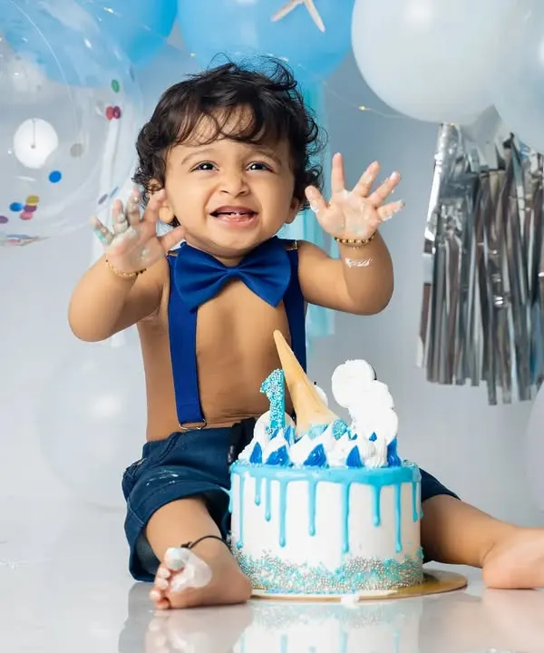That moment of pure delight right before the smashing begins. We set up the perfect blue and silver-themed backdrop for this little one's big celebration.