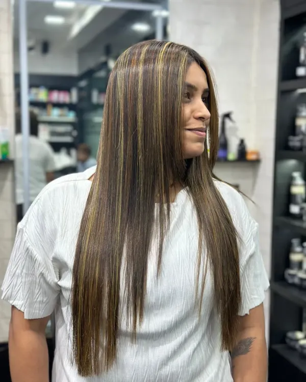 A perfect example of a smoothing treatment combined with subtle highlights. The hair is left incredibly straight, glossy, and frizz free, showing off the new color dimension beautifully.