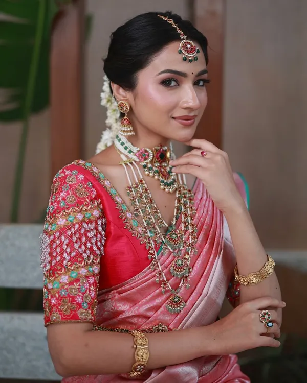 This is the essence of what I do: creating a timeless bridal look. This bride is wearing a custom-designed silk saree with a heavily hand-embroidered blouse, featuring intricate zardosi and beadwork that complements her traditional South Indian jewelry.