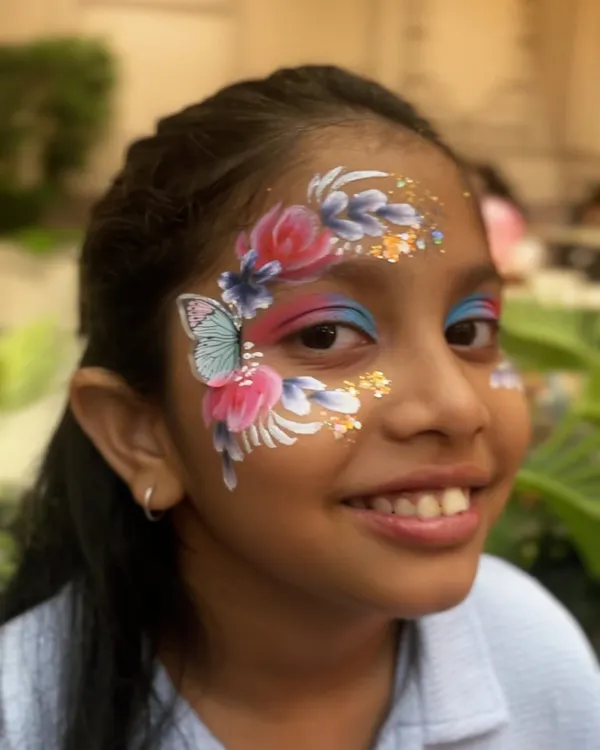 This is the kind of smile that makes my day. I created this vibrant butterfly and floral design, complete with a touch of glitter, to make this little one's day extra special. It's one of my most requested looks for birthday parties.