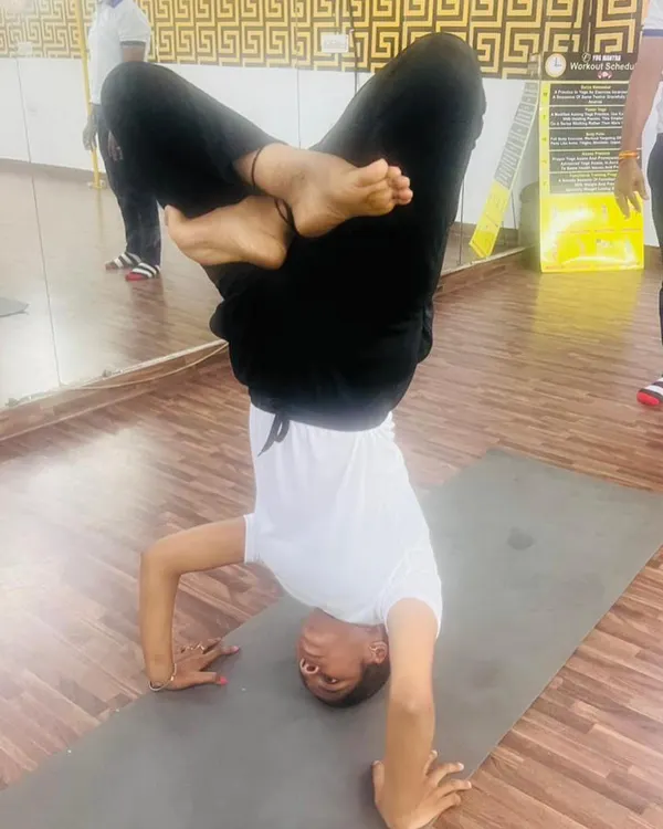 Mastering the tripod headstand, or Sirsasana II, with a lotus leg variation. This inversion requires immense core strength, balance, and concentration.