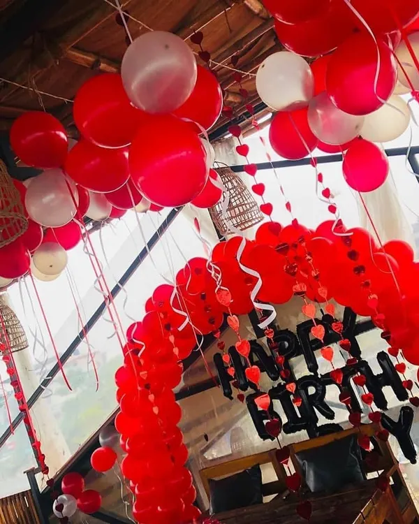 This birthday setup shows how a simple red and white color scheme can make a big impact. I created a full balloon arch over the seating area and filled the ceiling with balloons to create a festive party environment.