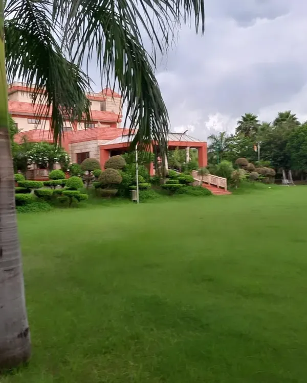Presenting a new farmhouse venue in Noida, perfect for weddings and corporate events. The expansive green lawn and beautiful architecture provide a versatile canvas for creating a memorable outdoor celebration.