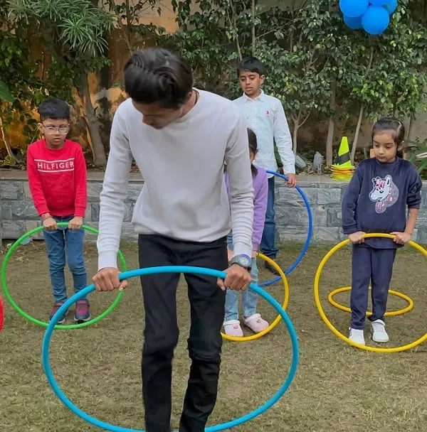 Learning to hula hoop is a great physical activity for kids of all ages. Here, an instructor guides the children during a fun session on our lawn.