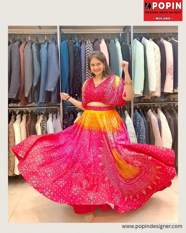 Twirl into the celebration with this vibrant pink and orange lehenga. The bandhani-inspired print and flowy skirt make it a fun and festive choice for a sangeet or mehendi.