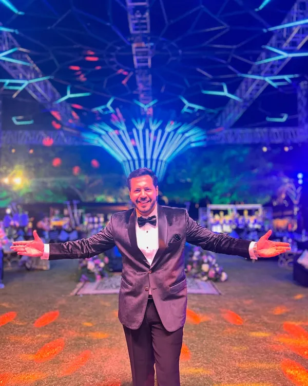 Welcome to the celebration. Dressed in a tuxedo and ready to host a spectacular Sangeet night under a stunningly decorated venue. This is where I make the magic happen.