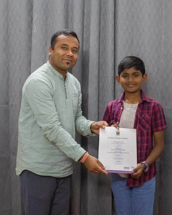 I am delighted to award a student his certificate for passing his graded music exam. I take great pride in my students' formal achievements.