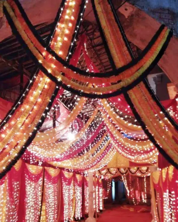This is a grand entrance gate I decorated for a large event. I used layers of marigold garlands and bright fairy lights to build a traditional and welcoming entryway for guests arriving at the venue.