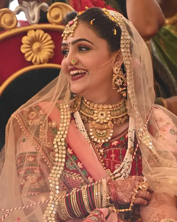 The pure joy of a bride on her wedding day. This look features a classic bold lip and defined eyes, a timeless combination for a traditional Gujarati wedding ceremony.