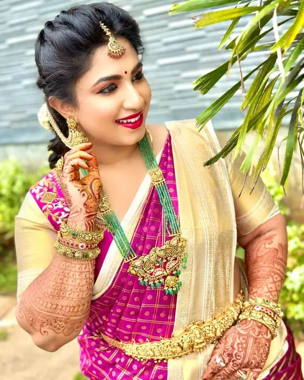 This is one of my favorite elegant looks. I focused on creating a radiant, glowing base for her skin, paired with a classic red lip and defined eyes, perfect for her beautiful silk saree and temple jewelry.