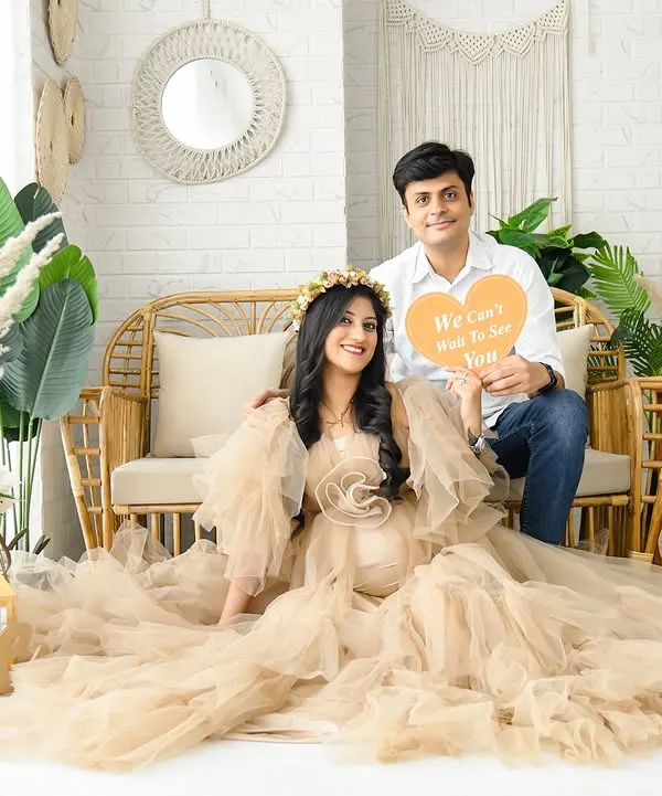 A lovely couple's portrait in our full boho-chic setup. The scene is filled with natural textures, from the rattan couch to the pampas grass and "LOVE" sign, creating a warm and inviting atmosphere.