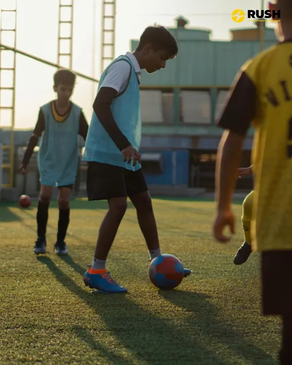 The sun sets, but the training continues. A young player practices close ball control, a fundamental skill we emphasize in every session to build confidence and composure on the ball.