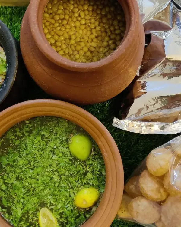 A closer look at our Pani Puri kit, complete with tangy mint-coriander water, sweet tamarind chutney, boiled chickpeas, and crispy puris. We serve the water in traditional clay pots for an authentic touch.