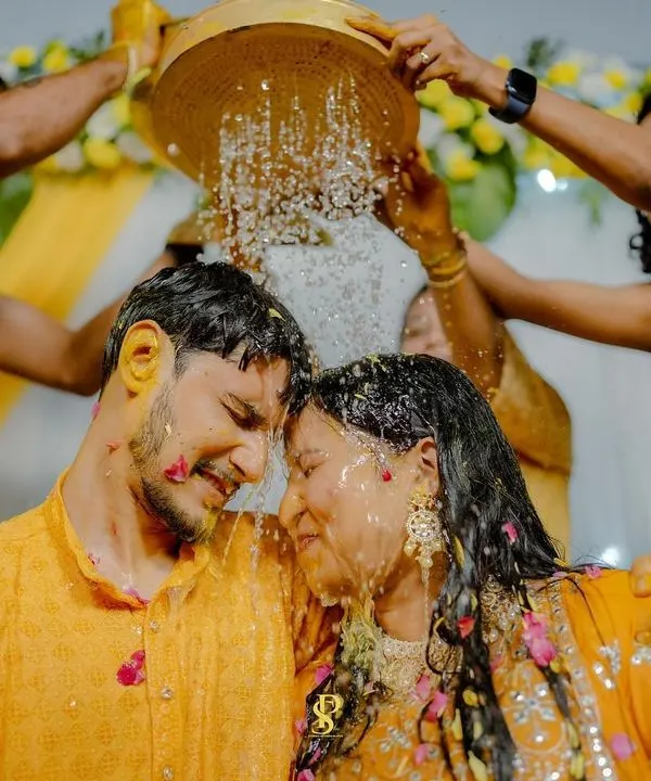 A shower of blessings and petals! This is a moment of pure bliss during the Haldi, where the couple is surrounded by the love and playful energy of their family and friends.