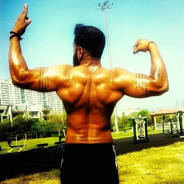Posing after an intense outdoor workout. A well-developed back shows true strength and dedication. This kind of muscle definition is built with hard work and fueled by quality supplements.