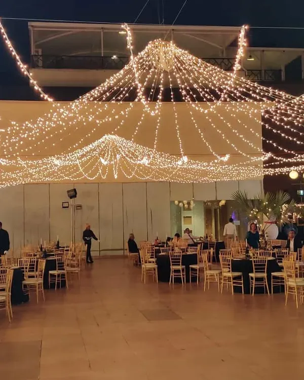 A wide view of an outdoor corporate gala I managed. The combination of a grand lighting canopy and well-spaced table arrangements shows how I handle layout planning for large gatherings to ensure both comfort and visual impact.