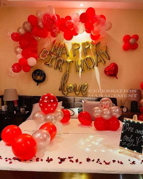 A perfect surprise for your partner's birthday. This setup combines romantic red and silver balloons with gold "Happy Birthday Love" foil letters, turning the bedroom into a personal and festive celebration space.