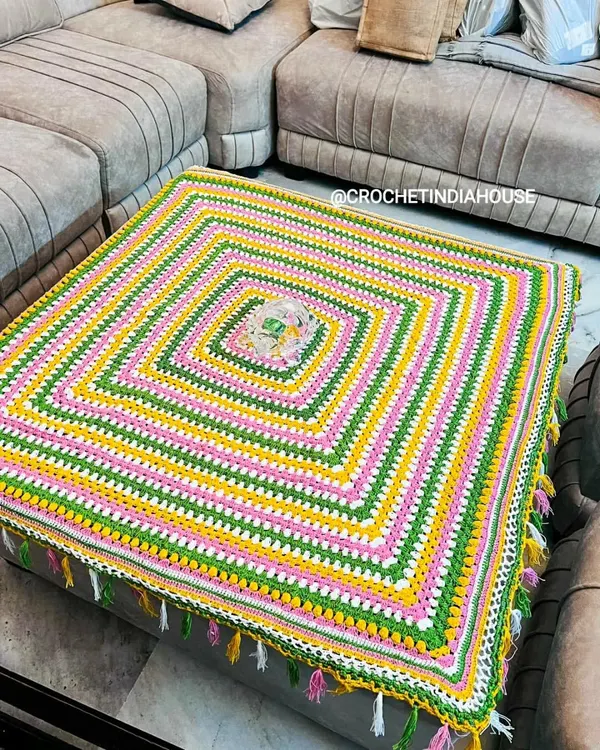 This large, square table cover was custom-made for a living room ottoman. The bright stripes and corner tassels add a playful and colorful touch to the space.