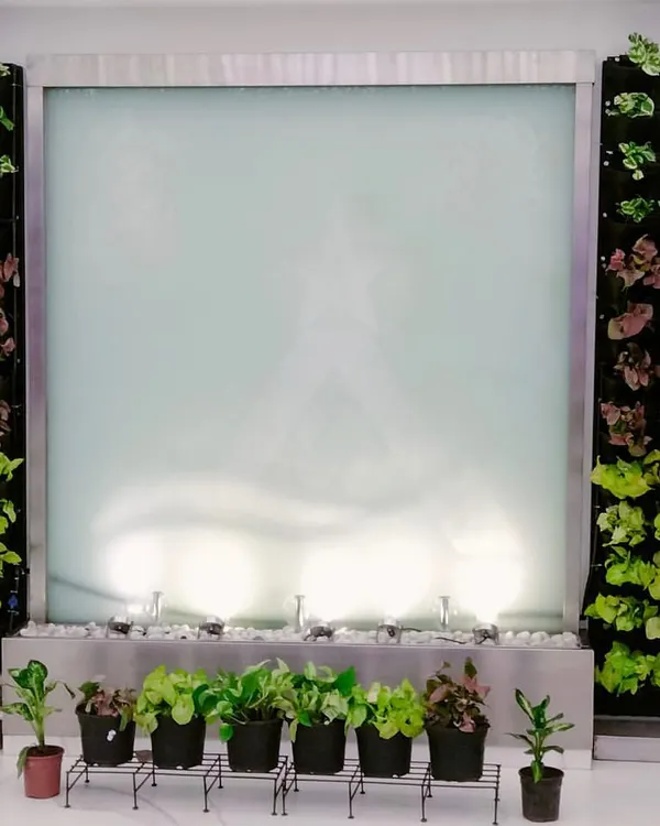 We designed this serene entrance by framing a modern water feature with two symmetrical vertical gardens. This installation transforms a simple wall into a living work of art, creating a calming and impressive welcome for visitors and employees. The combination of lush greenery and gentle water sounds promotes a tranquil atmosphere.