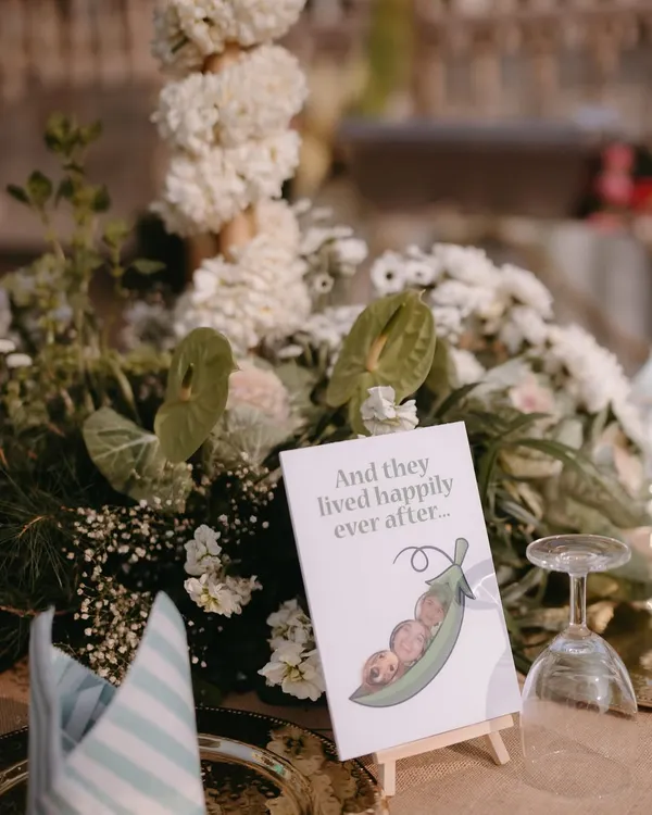 A sweet and personal touch on a table centerpiece placard, featuring a custom illustration of the couple and their beloved pet. We believe in celebrating the whole family.