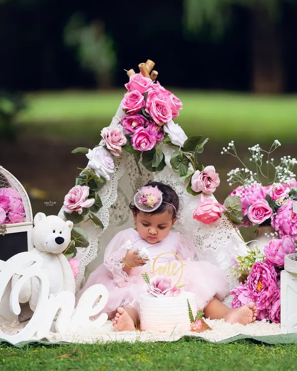 A beautiful first birthday cake smash in the park. This outdoor setup with a lace teepee and pink flowers creates a magical, bohemian vibe.