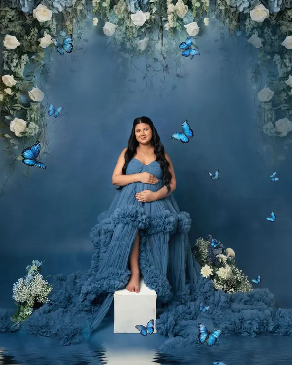 A fairytale comes to life. This dreamy setup with a floral arch, flowing blue gown, and magical butterflies is one of my most requested concepts.