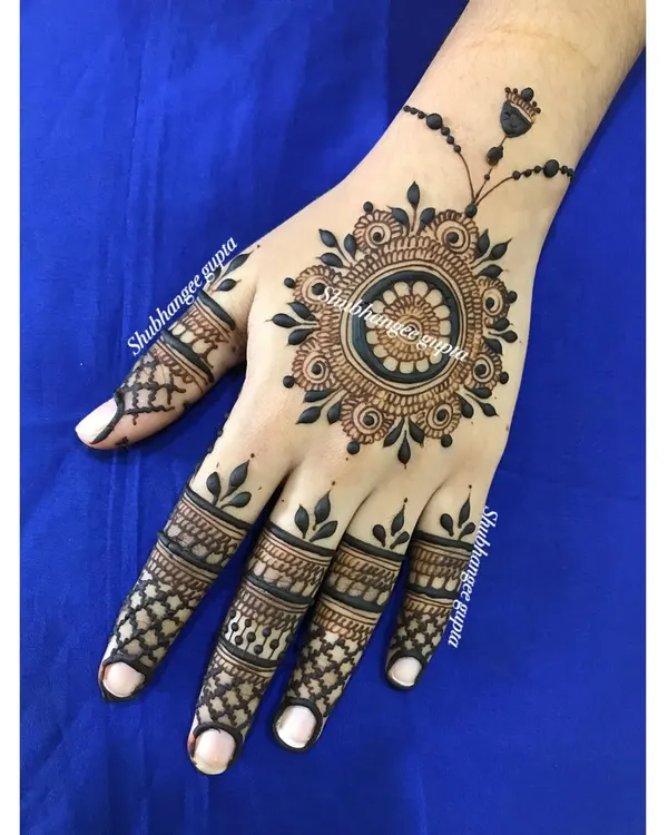 A perfect example of a minimal mandala design. The central mandala is connected to a delicate finger chain, creating a look that is modern, elegant, and chic.