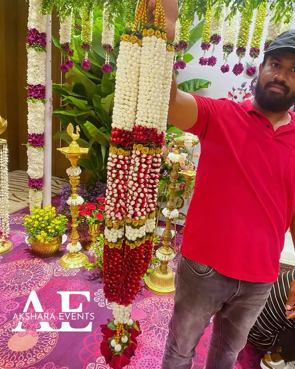 A very grand and heavy wedding garland I created, featuring thick strands of red and white flowers. This type of varmala is designed to be a magnificent part of the wedding attire.