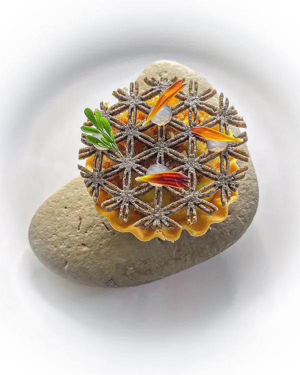 A corn tartlet with a chicken fat corn crema, puffed amaranth, and crispy chicken skin. A bite that is full of texture and savory flavor.