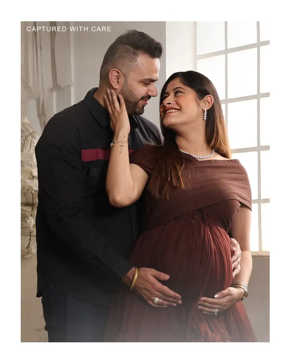 A tender moment between partners during their studio maternity shoot. The way they look at each other tells a story of love and shared anticipation for their new baby.
