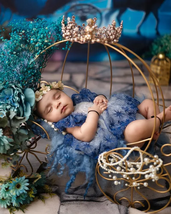A close-up of a sleeping princess in her royal blue gown, adorned with pearls and a crown. I focus on capturing these peaceful expressions and tiny details during my newborn photography sessions.