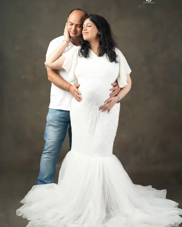 A gentle touch, a quiet moment together. This classic studio portrait against a simple backdrop focuses on the deep connection between you and your partner during this special time.