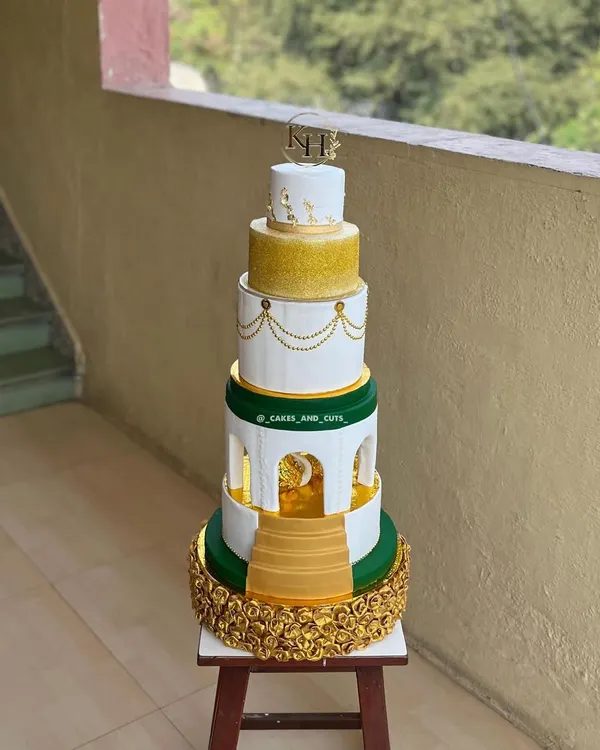 This five-tier royal engagement cake is a perfect example of a grand celebration centerpiece. It features intricate golden floral work, elegant archways, and a custom monogram topper, making it a truly memorable part of the ceremony.