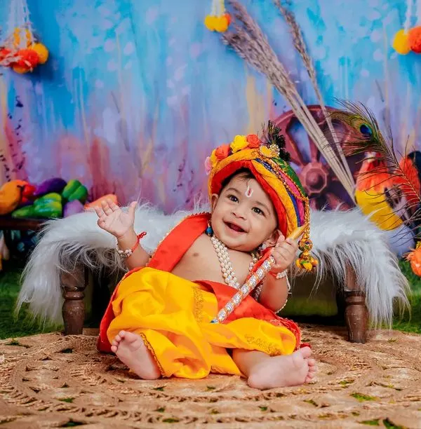 Navaratri moments with our little mischief-maker, Krishna. The vibrant colors of this setup are full of festive joy.