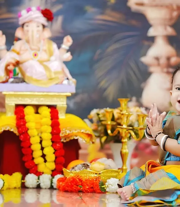 Pure joy and devotion. A toddler in a traditional saree claps her hands in delight during our Ganpati-themed photoshoot, available at our Taloja studio.