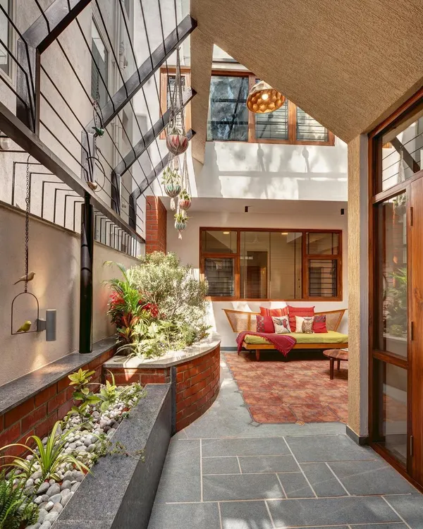 We designed this central courtyard to be a tranquil heart of the home. The combination of slate flooring, exposed brick, and lush tropical plants creates a private sanctum that connects the surrounding rooms to nature.