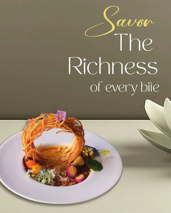 A dish designed to be savored. This plate features a nest of crispy noodles over a rich base, garnished with edible flowers, showcasing our commitment to creating rich, multi-textured culinary experiences.
