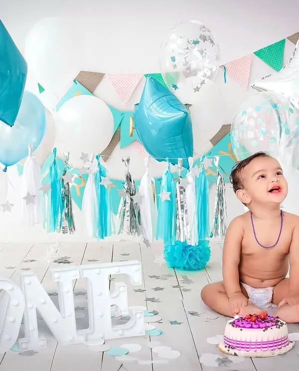 A classic first birthday cake smash is a perfect way to celebrate. I set up this bright and cheerful scene with a custom cake and balloons in my studio to capture this little boy's happy mess.