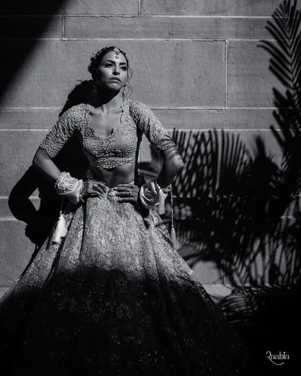 A powerful black and white bridal portrait of Amala. The dramatic shadows and strong pose at Umaid Bhawan Palace create a high-fashion, editorial look.