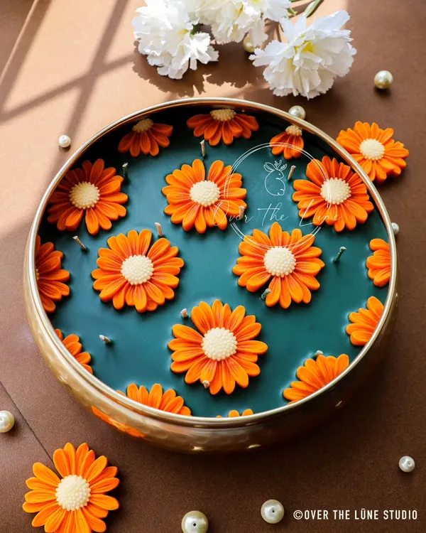 This was a very special custom order for a wedding gift: a grand 10-inch urli filled with bright orange daisy candles. The piece is scented with a beautiful blend of Jasmine and Ylang Ylang, making it a truly luxurious and memorable gift.