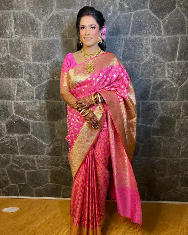 A full-length view of my beautiful reception bride in a stunning pink Banarasi saree. The makeup is bright and celebratory, with pink tones that echo the color of her outfit.