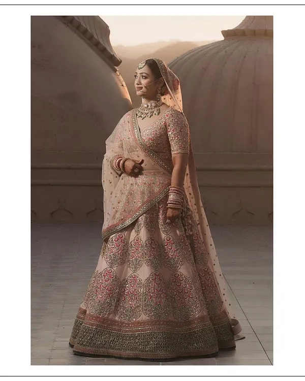 This is the beautiful result of a collaborative journey. For her Jaipur wedding, my bride Somya envisioned an outfit that was both regal and soft. We worked together to select this exquisite Sabyasachi lehenga, focusing on a pastel palette with intricate embroidery that would catch the golden hour light perfectly.