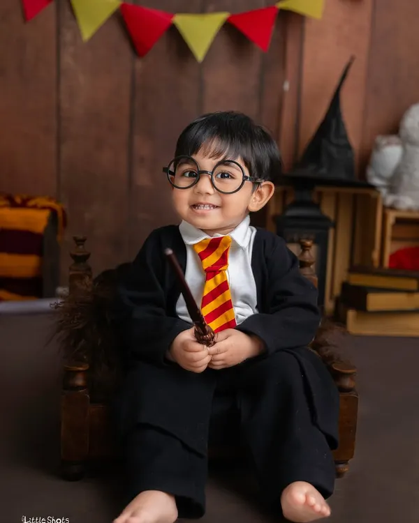 Expecto Patronum! This little wizard, dressed in his Hogwarts robe and glasses, is ready to cast a spell of cuteness in this magical Harry Potter themed photoshoot.